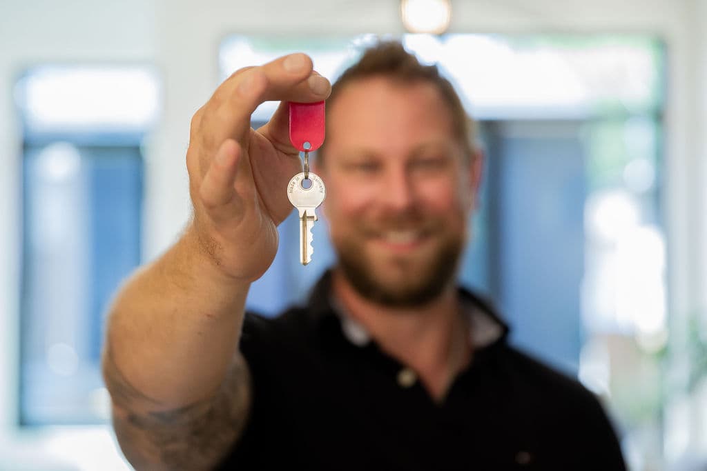 Stephen Schacher holding out a house key
